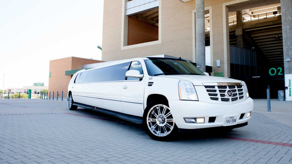 A look at the white limo parked in front of a building.