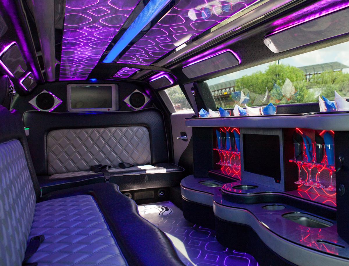 An interior of a limo in purple and red colors with a large window.