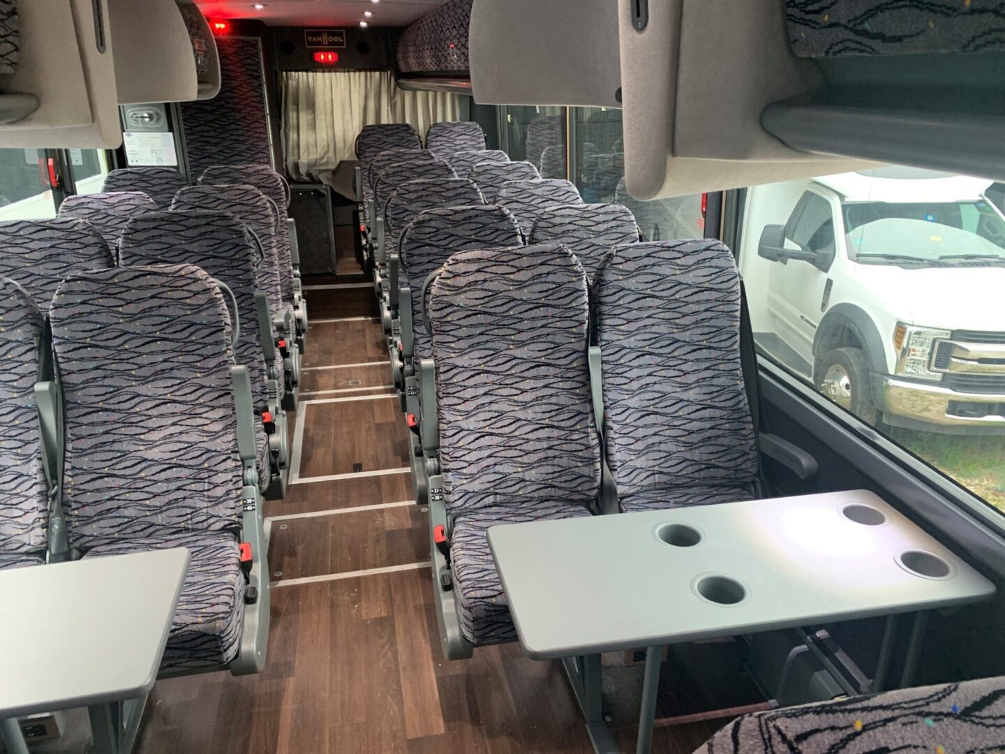 Empty bus seats with fold-down tables.