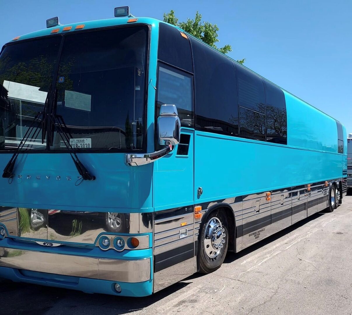 Blue tour bus parked on pavement.