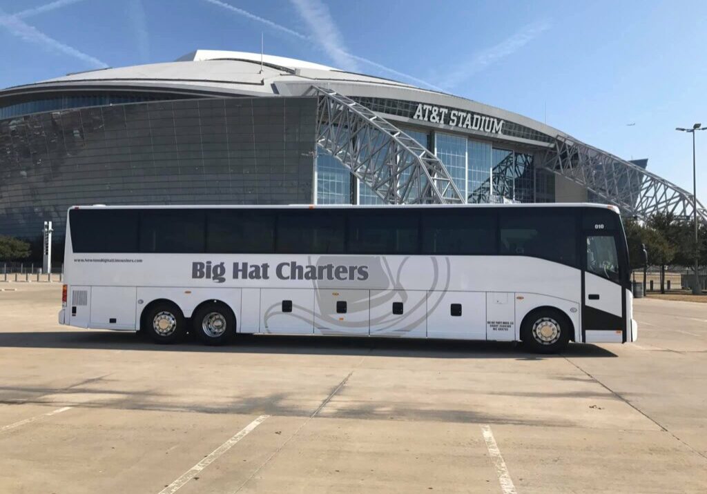 White charter bus parked near AT&T Stadium.