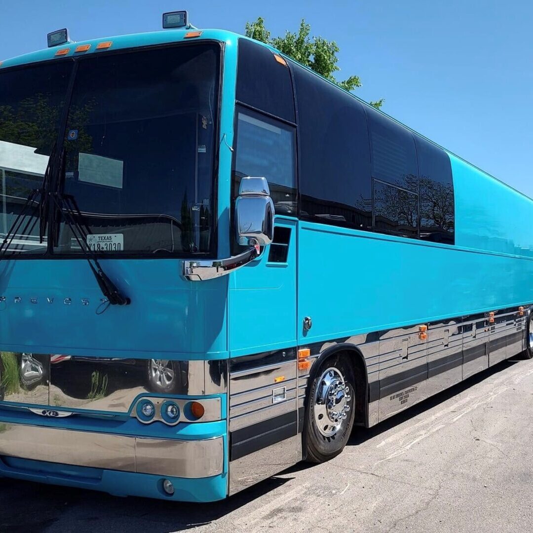 Blue tour bus parked on pavement.