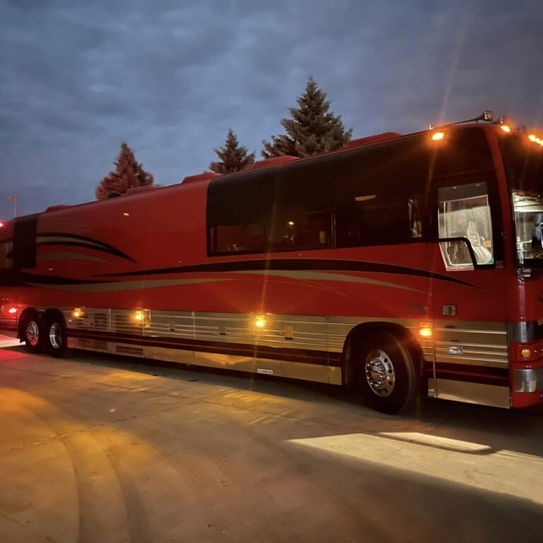 Red tour bus parked at night.