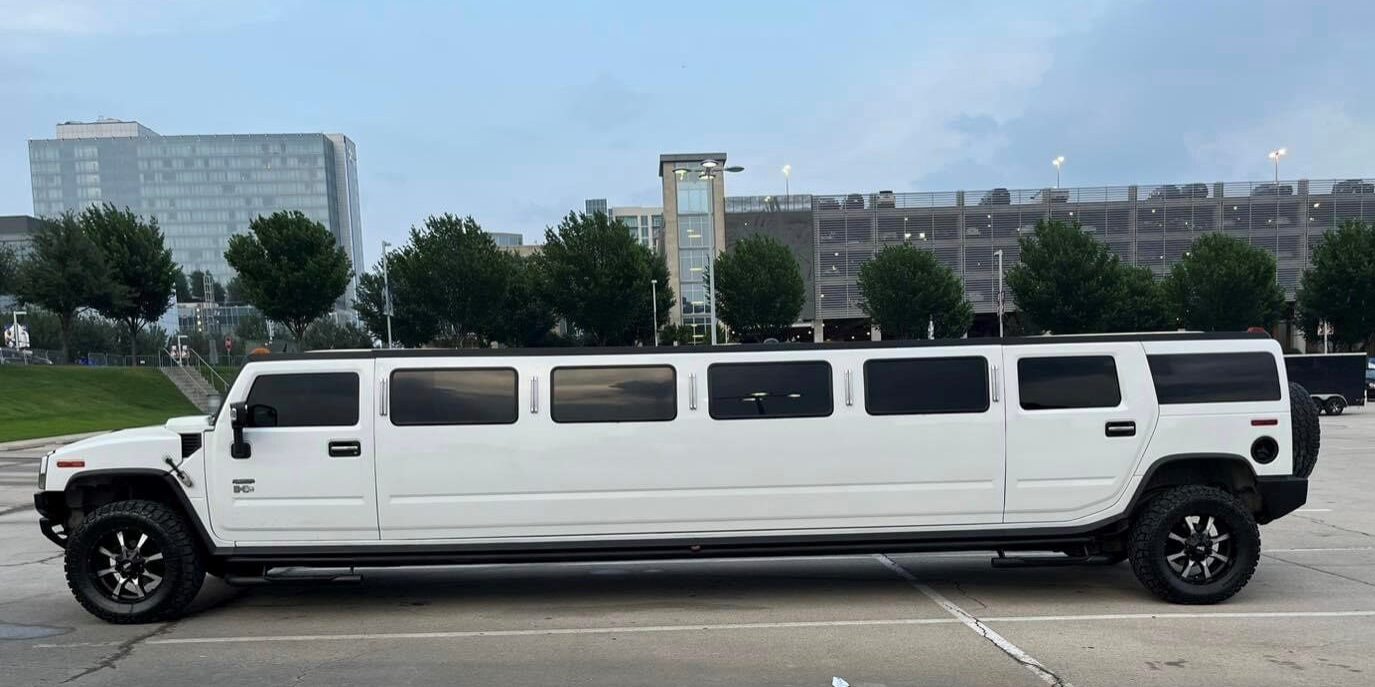 White Hummer limousine parked in lot.
